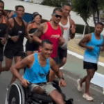 atleta de cadeira de rodas cercado por corredores