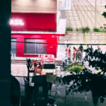 fachada de farmácia com viatura policial e pessoas na frente