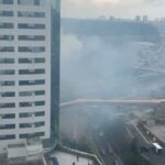 nuvem de fumaça por trás de edifício empresarial