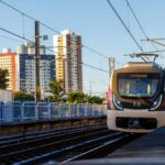 metrô andando sobre trilhos com prédios ao fundo