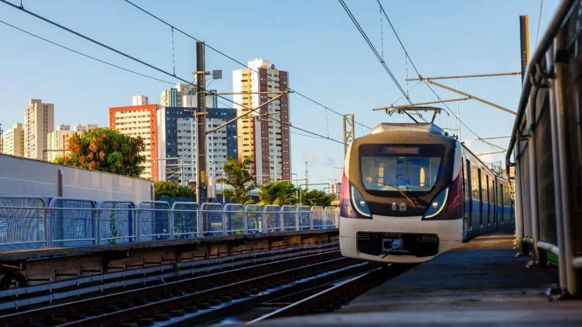 metrô andando sobre trilhos com prédios ao fundo