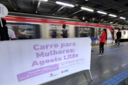faixa informativa sobre o vagão lilás em plataforma de metrô.